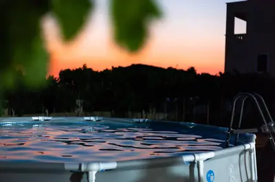 a hot tub with a sunset in the background at Garden house in Kremasti