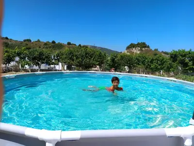 a young boy swimming in a large swimming pool at Garden house in Kremasti