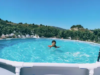 a young child swimming in a large swimming pool at Garden house in Kremasti