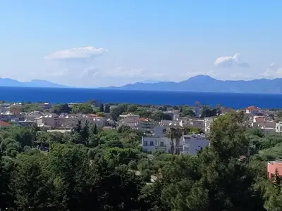 a city with the ocean in the background at Garden house in Kremasti