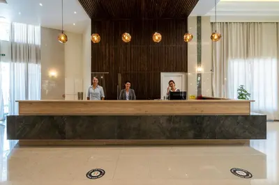 three people standing at a reception desk in a lobby at Castellum Suites - All Inclusive in Rhodes Town