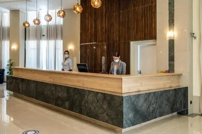 two people wearing face masks in a lobby at Castellum Suites - All Inclusive in Rhodes Town