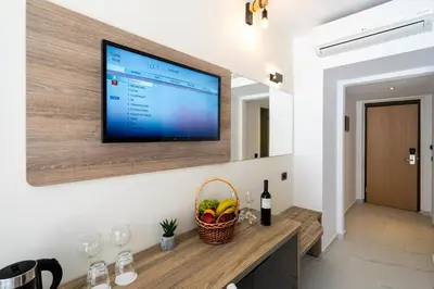 a flat screen tv hanging on a wall in a room at Castellum Suites - All Inclusive in Rhodes Town