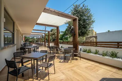 a restaurant with tables and chairs on a patio at Castellum Suites - All Inclusive in Rhodes Town