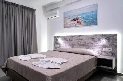 a bedroom with a bed with two towels on it at Aegean Horizon apartments in Gennadi
