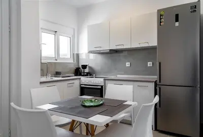 a kitchen with a table and chairs and a refrigerator at Aegean Horizon apartments in Gennadi
