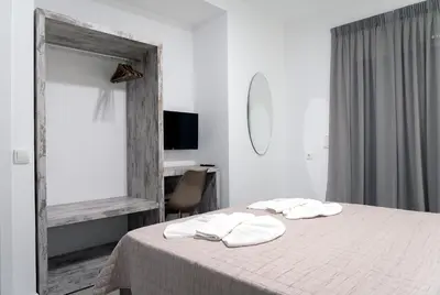 a bedroom with a bed with two white towels on it at Aegean Horizon apartments in Gennadi