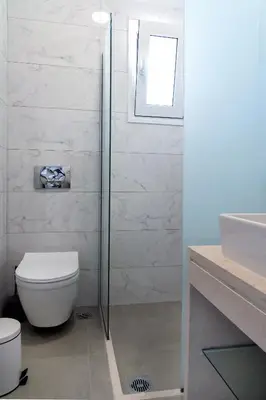 a bathroom with a shower and a toilet and a sink at Aegean Horizon apartments in Gennadi