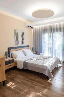 a bedroom with a large bed and a large window at Kolymbia memories house in Kolimbia