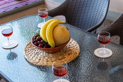 a bowl of fruit on a table with glasses of wine at Kolymbia memories house in Kolimbia