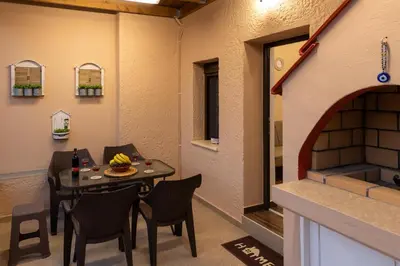 a room with a table and chairs and a fireplace at Kolymbia memories house in Kolimbia