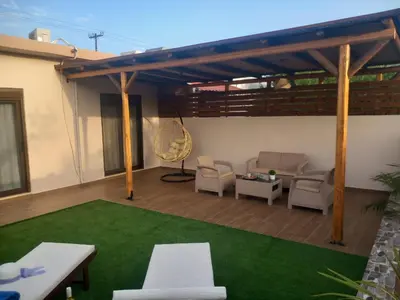 a patio with a couch and chairs and a table at Kolymbia memories house in Kolimbia
