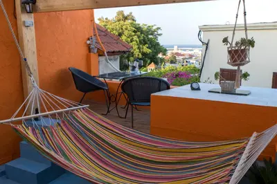 a hammock on a patio with a table and chairs at Casa de Mikel in Rhodes Town
