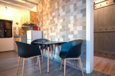 a kitchen with two chairs and a table and a brick wall at Casa de Mikel in Rhodes Town