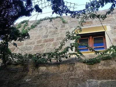a window on a brick building with a tree at Casa de Mikel in Rhodes Town