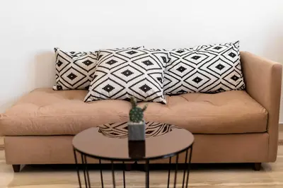 a couch with pillows and a table in a living room at Alia Apartments in Rhodes Town