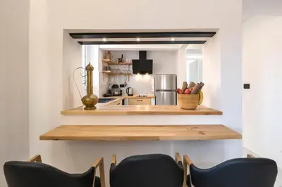 a kitchen with a counter and chairs in a room at Alia Apartments in Rhodes Town