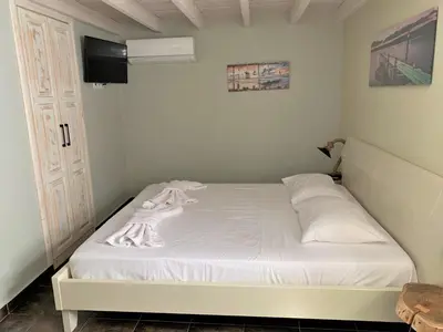 a small bedroom with a white bed in a room at Stone House Halki in Halki