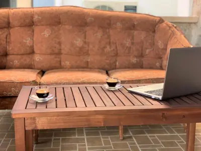 a coffee table with a laptop and two cups of coffee at Stone House Halki in Halki