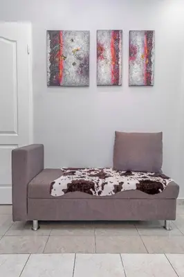 a couch in a room with three paintings on the wall at 3- Sea view luxury suite in the center of Rhodes! in Rhodes Town