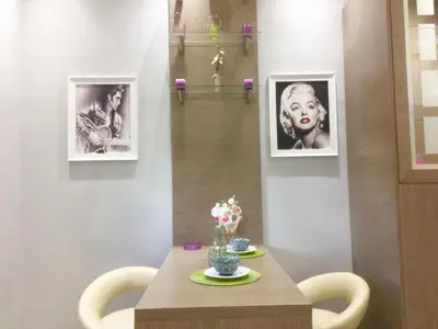 a table with two pictures of a woman on the wall at 6-Stylish mini-suite for 4 people in central Rhodes! in Rhodes Town