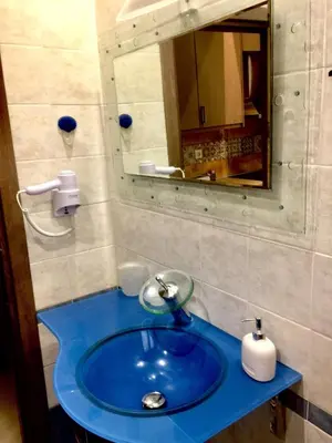 a bathroom with a blue sink and a mirror at 6-Stylish mini-suite for 4 people in central Rhodes! in Rhodes Town