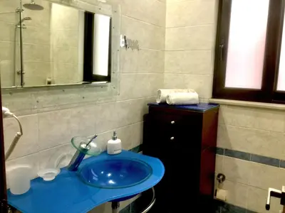 a bathroom with a blue sink and a mirror at 6-Stylish mini-suite for 4 people in central Rhodes! in Rhodes Town