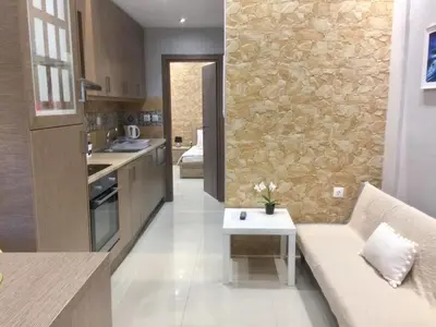 a kitchen and living room with a stone wall at 6-Stylish mini-suite for 4 people in central Rhodes! in Rhodes Town