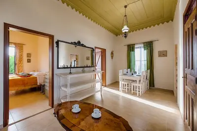 a living room with a table and a mirror at Kristina´s Apartments in Rhodes Town