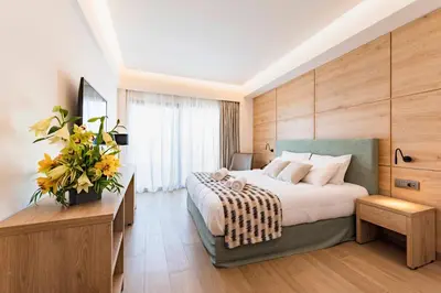 a bedroom with a large bed and a large window at Acandia Hotel in Rhodes Town