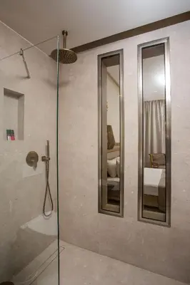 a bathroom with a shower with a glass door at Ladiko Suites - Faliraki in Faliraki