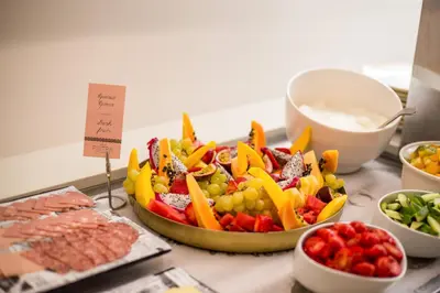 a table topped with a tray of fruit and vegetables at Ladiko Suites - Faliraki in Faliraki