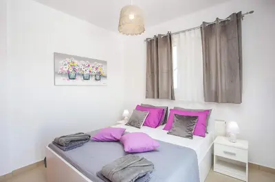 a bedroom with pink and grey pillows on a bed at La Casa Del Amor in Kalithies