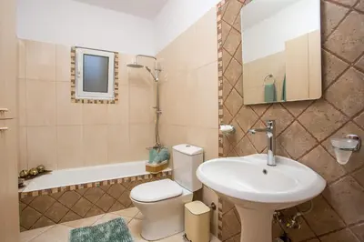 a bathroom with a sink and a toilet and a tub at La Casa Del Amor in Kalithies