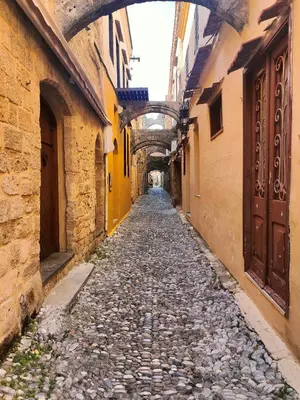 an alley in an old town with an arcade at Megiston House in Old Town Rhodes in Rhodes Town