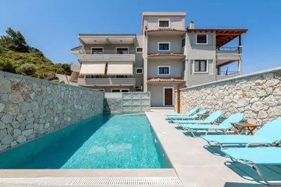 a villa with a swimming pool in front of a building at Villa Divina in Kremasti
