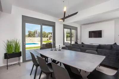 a living room with a table and a couch at Modern Villa with Pool & Garden Kastalys, Rhodes in Kalithies