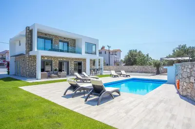 a villa with a swimming pool and a house at Modern Villa with Pool & Garden Kastalys, Rhodes in Kalithies