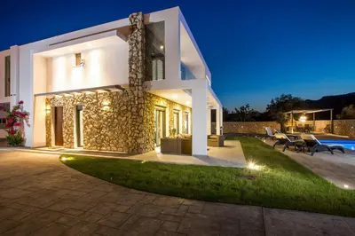 a villa with a swimming pool at night at Modern Villa with Pool & Garden Kastalys, Rhodes in Kalithies