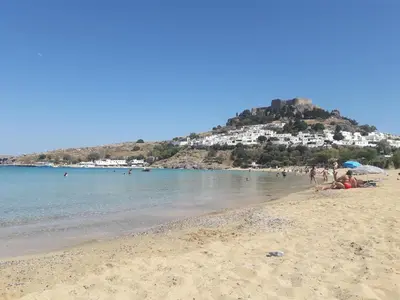 a group of people on a beach with a hill at PHILIPPOS STUDIOS & APT in Líndos