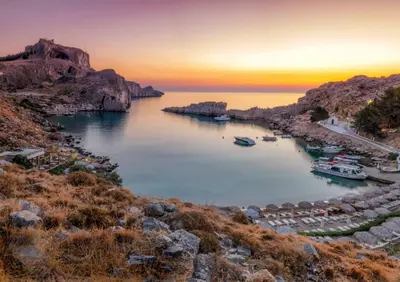 a group of boats in a harbor at sunset at PHILIPPOS STUDIOS & APT in Líndos