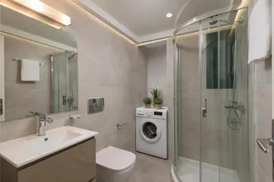 a bathroom with a sink and a washing machine at Kite Blue Villas in Kattavía