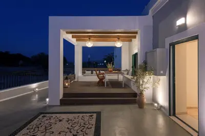 a porch of a house with a table and chairs at Kite Blue Villas in Kattavía