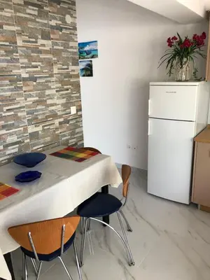 a kitchen with a table and chairs and a refrigerator at Chrysanthi’s in Faliraki