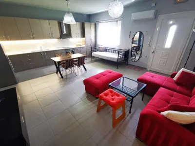 a living room with red couches and a table at Villa MATA - 600m² with Private Pool and Jacuzzi in Kalithies