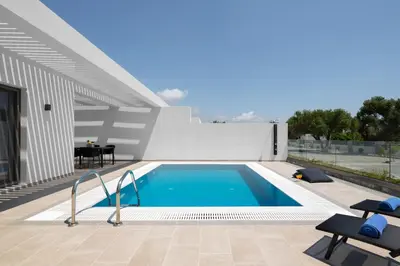 a swimming pool in the backyard of a house at Armonia Suites in Gennadi