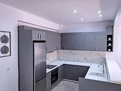 a kitchen with gray cabinets and white counter tops at Rodini House in Rhodes Town