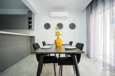 a dining room table with black chairs and a vase with flowers at Rodini House in Rhodes Town