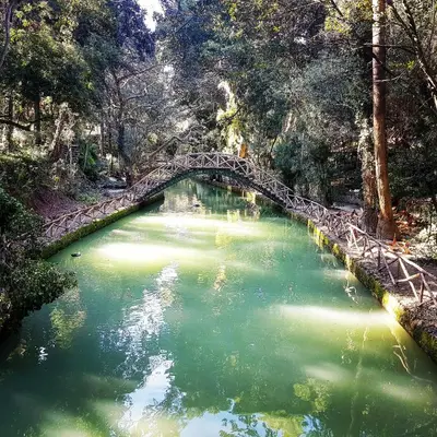 a bridge over a river with green water at Rodini House in Rhodes Town