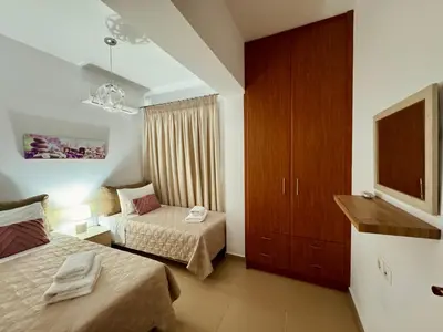 a hotel room with two beds and a television at Archangelos Garden House in Archangelos
